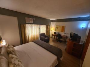 a hotel room with a bed and a desk at Flat Borges Lagoa Ibirapuera c/ garagem UH508 in Sao Paulo