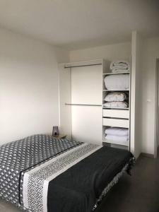 ein Schlafzimmer mit einem Bett und einem Schrank mit Handtüchern in der Unterkunft Maison 8 personnes impasse Paradis in Saint-Ambroix