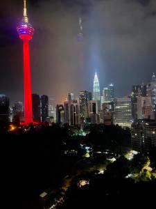una torre iluminada en una ciudad por la noche en Ceylonz Suite, en Kuala Lumpur