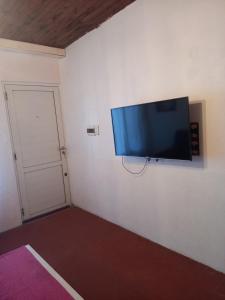a flat screen tv hanging on a wall at " Departamento Avenida" a 3 cuadras de la laguna y 3 del centro in Chascomús
