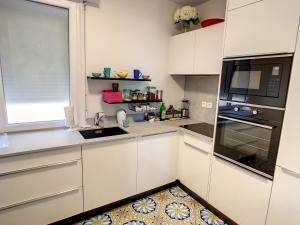 a kitchen with white cabinets and a kitchen rug at 2 bedroom, 2 bathrooms Suquet with sea view 314 in Cannes