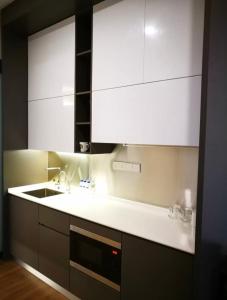 una cocina con armarios blancos y fregadero en Ceylonz Suite, en Kuala Lumpur