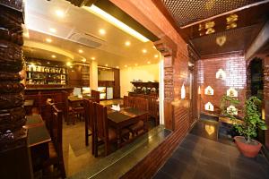 a restaurant with a table and chairs and a bar at Capital Boutique Hotel in Kathmandu