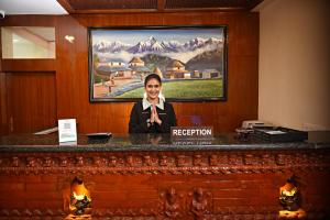 a woman is sitting at a reception desk in a room at Capital Boutique Hotel in Kathmandu