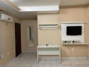 ein Wohnzimmer mit einem TV an der Wand in der Unterkunft Hotel Central Gold in Manaus