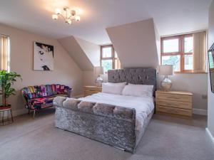 a bedroom with a large bed and a couch at Grandeur Homes Sheffield in Heeley