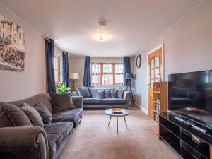 a living room with a couch and a tv at Grandeur Homes Sheffield in Heeley