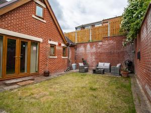 a backyard with a patio furniture and a brick building at Grandeur Homes Sheffield in Heeley