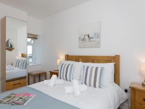 a bedroom with a white bed with striped pillows at Pass the Keys Spectacular Sea View Apartment with free Parking in Trearddur