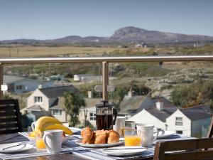 a table with plates of food and bananas and coffee at Pass the Keys Spectacular Sea View Apartment with free Parking in Trearddur