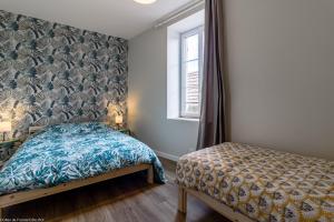 una camera da letto con un letto e una finestra di Le Pigalle a Nolay