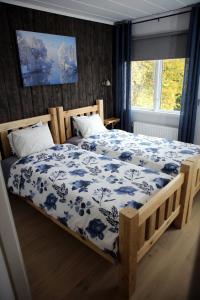 a bedroom with a bed with a blue and white blanket at Wärdshuset Klarälvdalen in Sysslebäck