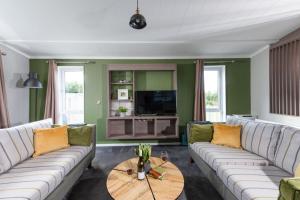 ein Wohnzimmer mit weißen Sofas und einem Holztisch in der Unterkunft Daisy Lodge, 6 Roadford Lake Lodges in Lifton