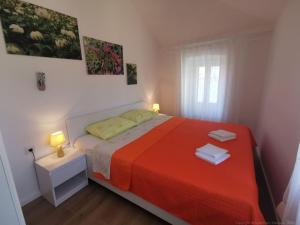a bedroom with a large bed with a red blanket at Guesthouse Stivan (920) in Štivan