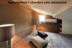 アルルにあるHoliday in Arles -Appartement du Théâtre Antiqueのベッドルーム(ベッド1台、ランプ付)