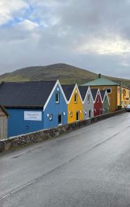 une rangée de maisons colorées sur le côté d'une route dans l'établissement Cottages by the Sea, à Sørvágur