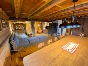 a living room with a table and a couch at Gîte Le Chut - Piscine chauffée - 11 à 14 personnes in Rangen