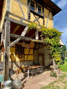 a house with a table and chairs in front of it at Gîte Le Chut - Piscine chauffée - 11 à 14 personnes in Rangen