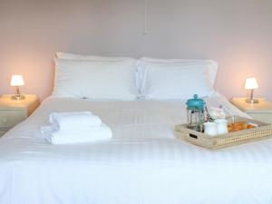 a white bed with a tray of towels and two lamps at Spacious family home close to Llandeilo in Llandeilo