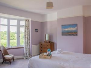 a bedroom with a bed and a chair and a window at Spacious family home close to Llandeilo in Llandeilo