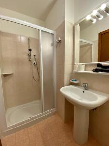 ein Bad mit einer Dusche, einem Waschbecken und einer Dusche in der Unterkunft Hotel Rosa Caorle in Caorle