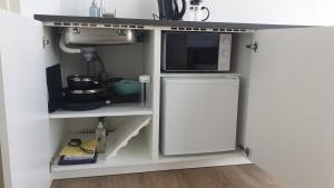uma cozinha com um lavatório e um micro-ondas em Cottages by the Sea em Sorvágur