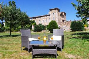 a table with two chairs and a table with drinks on it at Gite du Chateau in Éclassan