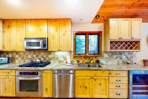 a kitchen with wooden cabinets and stainless steel appliances at St Bernard Oasis in Truckee +29 photos