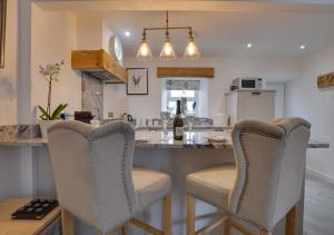 a kitchen with a bar with chairs and a counter at Naw Stryd y Capel in Conwy