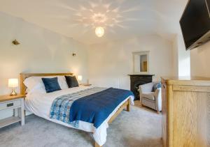 a bedroom with a bed and a flat screen tv at Maes y Llan in Caernarfon