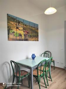 stół jadalny z krzesłami i obraz na ścianie w obiekcie ATTICO RUCELLAI CON TERRAZZA SUPER VISTA we Florencji