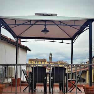 patio ze stołem i krzesłami na dachu w obiekcie ATTICO RUCELLAI CON TERRAZZA SUPER VISTA we Florencji