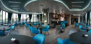 een restaurant met blauwe stoelen en tafels bij Hotel Laktaši in Laktaši