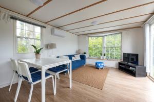 - un salon avec une table et des chaises blanches dans l'établissement 87, gelegen in het rustige & bosrijke Oisterwijk!, à Oisterwijk