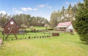 a barn and a house in a field at Gorgeous Home In Jedwabno With Kitchen in Jedwabno