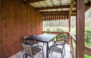 a wooden porch with a table and chairs at Gorgeous Home In Jedwabno With Kitchen in Jedwabno