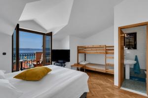 a bedroom with a bed and a balcony at Room 79-7 in Duće