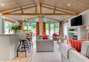 a living room with a couch and a table at Llyn Dinas Lodge in Betws-y-coed