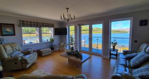 a living room with couches and a view of the water at Heatherfield House B&B in Portree