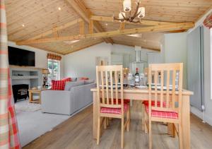 a kitchen and living room with a table and chairs at Llyn Dinas Lodge in Betws-y-coed