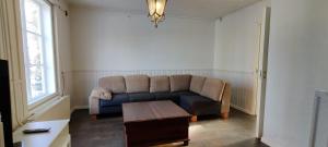 un salon avec un canapé et une table dans l'établissement Kirstulan Kartanon päärakennuksen upea päätyhuoneisto, à Hämeenlinna