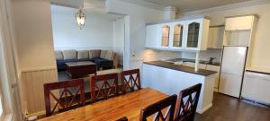 une cuisine et une salle à manger avec une table et des chaises dans l'établissement Kirstulan Kartanon päärakennuksen upea päätyhuoneisto, à Hämeenlinna