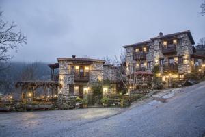 a large stone house with lights on it at T'Asprolithia in Kalyvia Fylaktis