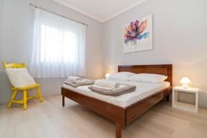 sypialnia z łóżkiem z krzesłem i oknem w obiekcie Apartment in Betina 3837-3 w mieście Betina