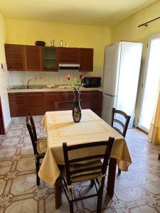kuchnia ze stołem z wazonem kwiatów w obiekcie Casa mare e montagna w mieście Bonarcado