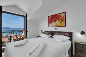 a bedroom with a bed with white sheets and a balcony at Room 79-8 in Duće