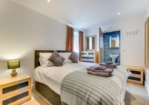 1 dormitorio con 1 cama con toallas en Llofft Marian, en Llangadwaladr