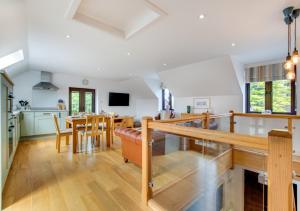 a kitchen and dining room with a table and chairs at Llofft Marian in Llangadwaladr