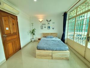 a bedroom with a bed in a room with a door at Yana House Phnom Penh in Phnom Penh