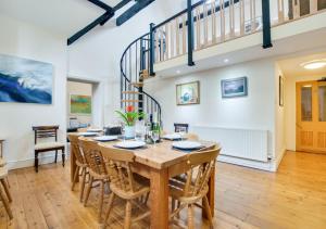 a large dining room with a wooden table and chairs at Lletyr Plas in Llanbedrog